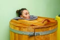 Woman in wooden hot tub, barrel sauna or cedar bathtub