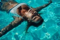 Woman relaxing swimming pool. Happy woman in a blue swimsuit floating in the pool, look form above Royalty Free Stock Photo