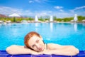 Woman looks out of the pool, hanging on the railing. Royalty Free Stock Photo