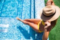 Woman relaxing on the swimming pool water in hot sunny day. Summer holiday idyllic.