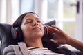 Woman Relaxing Taking A Break Lying On Sofa Listening To Music On Wireless Headphones