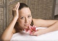 Woman relaxing on towel in stylish wooden bathroom with flowers, organic skin care, luxury spa hotel, lifestyle photo Royalty Free Stock Photo