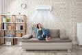 Woman Relaxing Under The Air Conditioner Royalty Free Stock Photo