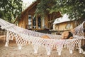 Woman relaxing in the white macrame hammock on tropical beach. Travel, leisure