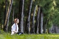 Woman relaxingly practicing meditation in the pine forest to attain happiness from inner peace wisdom for healthy mind and soul