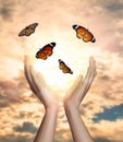 Woman releasing butterflies against sky outdoors, closeup. Freedom concept