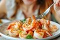 Woman relishes boiled prawns close up