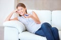 Woman, remote control and watching tv on couch, happy at home with entertainment and streaming with internet Royalty Free Stock Photo