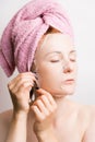 Woman removes cosmetic mask on face on light background Royalty Free Stock Photo