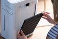 Woman removes filter from air purification system