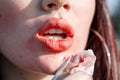Woman removes lipstick from lips outdoors