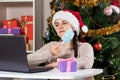 A woman removes a medical mask from her face, making online purchases via the Internet