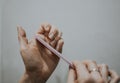 Woman removes nail length with nail file by herself at home. File nails, body hygiene