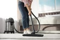 Woman removing dirt from carpet with vacuum cleaner at home Royalty Free Stock Photo