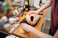 Woman removing fat from fresh Capon Chapon cockerel meat kitchen wooden top