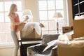 Woman removing lamp from moving box at new house Royalty Free Stock Photo