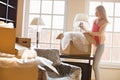 Woman removing lamp from moving box at new house Royalty Free Stock Photo