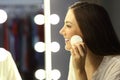 Woman removing make up in a mirror