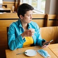 Woman removing the mask and drinking coffee