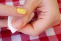 Woman removing nail polish on red table cloth background close up view Royalty Free Stock Photo