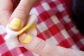 Woman removing nail polish on red table cloth background close up view Royalty Free Stock Photo