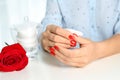 Woman removing nail polish at white table Royalty Free Stock Photo