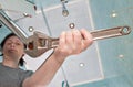 Woman removing old tap aerator using an adjustable plumbing span Royalty Free Stock Photo