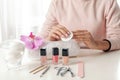 Woman removing polish from nails with cotton pad at table Royalty Free Stock Photo