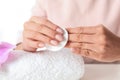 Woman removing polish from nails with cotton pad at table Royalty Free Stock Photo