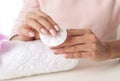 Woman removing polish from nails with cotton pad at table Royalty Free Stock Photo