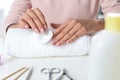 Woman removing polish from nails with cotton pad at table Royalty Free Stock Photo