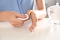 Woman removing polish from nails with cotton pad at table, Royalty Free Stock Photo