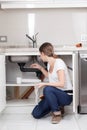 Woman repairing the pipe of the kitchen Royalty Free Stock Photo