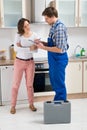 Woman And Repairman In Kitchen Royalty Free Stock Photo