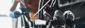 Woman repairman in rubber gloves repairing bike with tools closeup