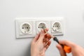 a woman repairs an electrical outlet with a screwdriver. Installing a new outlet in the wall Royalty Free Stock Photo