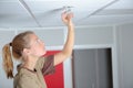Woman replacing bulb in overhead spotlight Royalty Free Stock Photo