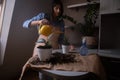 A woman repotting houseplants in pots, indulging in gardening and nurturing indoor greenery. This image captures the beauty of