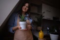 A woman repotting houseplants in pots, indulging in gardening and nurturing indoor greenery. This image captures the beauty of