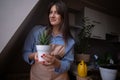 A woman repotting houseplants in pots, indulging in gardening and nurturing indoor greenery. This image captures the beauty of