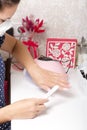 A woman with a respirator on her face gets a manicure. Removes old nail Polish with a nail buff