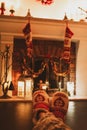 Woman is rest by the fireplace in red slippers on Holidays. Closeup photo of feet in woolen socks. Royalty Free Stock Photo