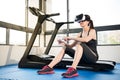 Woman rest treadmill with VR headset control by smartphone Royalty Free Stock Photo