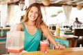 Woman In Restaurant Making Fruit Smoothies