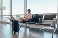 Woman resting in arrival hall waiting for a transfer at airport Royalty Free Stock Photo