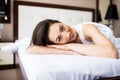 Woman resting in bed with hands under her head on the pillow in the morning. Royalty Free Stock Photo