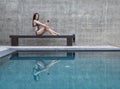 Woman on chair and holding a glass in swimming pool Royalty Free Stock Photo