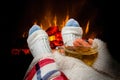 Woman resting with cup of tea near fireplace Royalty Free Stock Photo