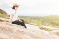 Woman Resting Happily on a Rock Outcropping