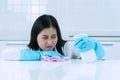 Woman resting her head and arms on the table while wiping in the kitchen. Unhappy housewife wear apron and blue gloves Royalty Free Stock Photo